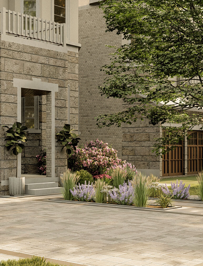 Garden at residential entryway with pink oleander, lavender, and ornamental grasses, framed by a stone facade and a mature tree.